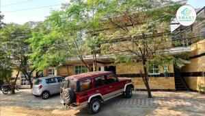 a red jeep parked in front of a building at B&B Apartment & Hotels in Lahore