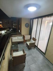 einen Balkon mit Stühlen und ein Bett in einem Gebäude in der Unterkunft departamento Arica verano 2 habitaciones in Arica