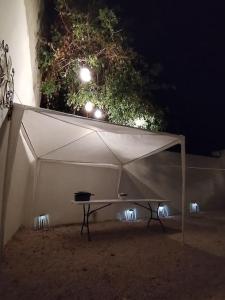 una tienda blanca con una mesa debajo por la noche en La casa de los Pajaritos en Chetumal