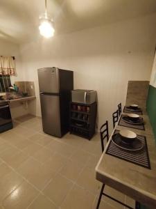 a kitchen with a refrigerator and a table with chairs at La casa de los Pajaritos in Chetumal