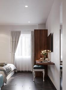 een slaapkamer met een bureau, een bed en een raam bij LANGHAM Boutiqu Hotel in Ho Chi Minh-stad