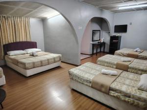Sri Juliana Chalet في تاناه راتا: غرفة فندقية بسريرين وطاولة