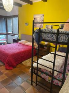 1 dormitorio con 2 literas y pared amarilla en B&B Happy Days Breakfast, en Sirmione