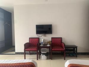 a room with two chairs and a table and a tv at Sapa Crown Hotel in Sapa