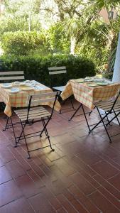 2 mesas y sillas sentadas en un patio en B&B Happy Days Breakfast, en Sirmione