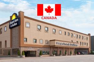 a large building with a sign on the side of it at Days Inn & Suites by Wyndham Sault Ste. Marie ON in Sault Ste. Marie