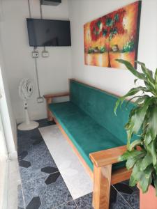 eine grüne Bank in einem Zimmer mit Ventilator in der Unterkunft Playa Mendoza Rest in Necoclí