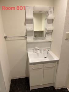a bathroom with a sink and a refrigerator at SkyHotel Kikukawa 駅徒歩2分 in Tokyo