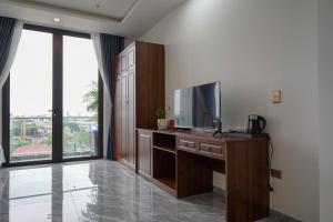 een woonkamer met een tv en een groot raam bij GOLDEN JOY HOTEL & APARTMENT in Hai Phong
