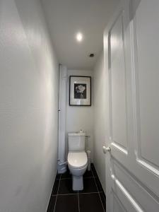 ein Badezimmer mit Toilette und einem Bild an der Wand in der Unterkunft Paris Serenity Bedroom [Female guest only] in Courbevoie