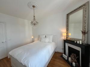 ein weißes Schlafzimmer mit einem Bett und einem Spiegel in der Unterkunft Paris Serenity Bedroom [Female guest only] in Courbevoie