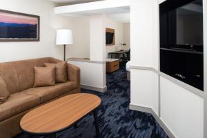 a living room with a couch and a table at Fairfield Inn & Suites Greensboro Wendover in Greensboro