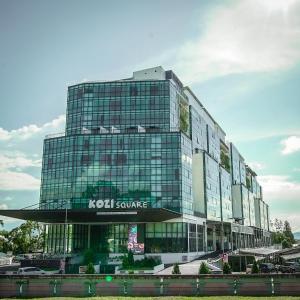 um edifício com um sinal de serviço koci em frente em Regatta Suites Hotel at Kozi Square Kuching em Kuching