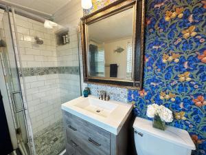 a bathroom with a sink and a mirror and a toilet at Salty Dog Cottage in Surfside Beach +24 photos
