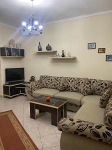 a living room with a couch and a tv at apartment in the city center in Durrës