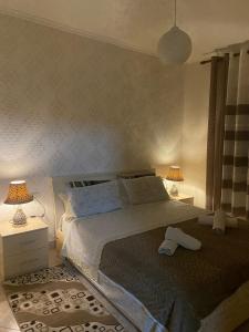 a bedroom with a large bed with two lamps at apartment in the city center in Durrës