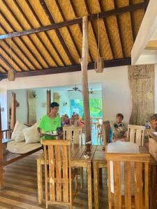 un groupe de personnes assises autour d'une table dans un restaurant dans l'établissement Green Coco House, à Amed