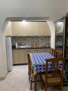 a kitchen with a table and chairs and a refrigerator at apartment in the city center in Durrës