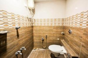 a bathroom with a toilet and a shower at Hotel Krishna Naroda in Ahmedabad