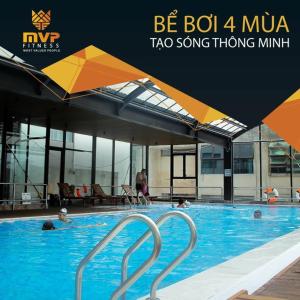a swimming pool with people in the water and umbrellas at Hi-Home - City view apartment in HongKong Tower in Hanoi