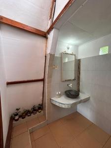 La salle de bains est pourvue d'un lavabo et d'un miroir. dans l'établissement We'Be Cottages, à Gili Meno