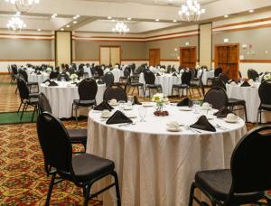 einen Bankettsaal mit weißen Tischen und Stühlen in der Unterkunft Holiday Inn West Yellowstone, an IHG Hotel in West Yellowstone