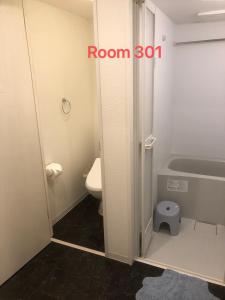 a bathroom with a toilet and a room sign at SkyHotel Kikukawa 駅徒歩2分 in Tokyo