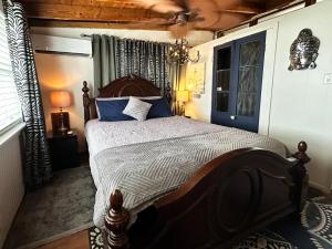 a bedroom with a large bed with blue pillows at Salty Dog Cottage in Surfside Beach