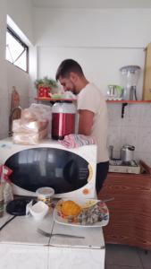 um homem de pé numa cozinha ao lado de um balcão em Posada de Mary em Sucre