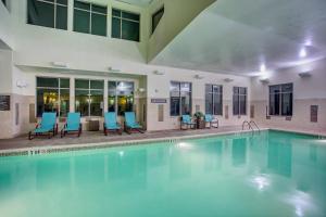 - une piscine avec des chaises bleues dans un bâtiment dans l'établissement Residence Inn Jackson, à Jackson