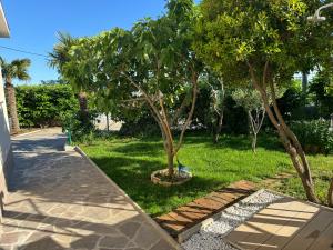 a garden with two trees and a sidewalk at Casa Fiumana Laura in Rijeka