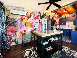 a kitchen with a colorful wall with a bird mural at Salty Dog Cottage in Surfside Beach