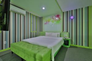 K2 Motel في بوسان: غرفة نوم مع سرير كبير مع مقاعد خضراء