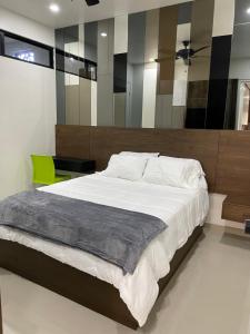 a bedroom with a large bed and a green chair at LOFT 3 Tulum in Mexicali
