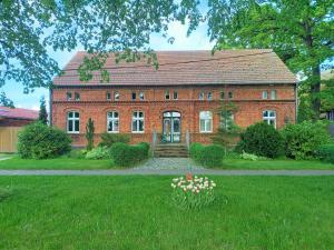 a large red brick house with a yard with flowers at Zur Alten Tabakscheune in Buchholz