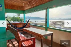 a porch with a hammock and a view of the ocean at Nias Falaga Home in Lagudri