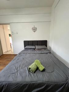 uma cama com duas toalhas em cima em Seruni Apartment em Serendah