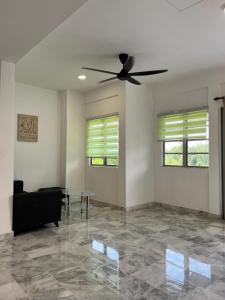 uma sala de estar com uma ventoinha de tecto e uma mesa de vidro em Seruni Apartment em Serendah