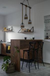 a kitchen with a wooden island with two stools at Nouvel Appartement Moderne À La Corniche De Bizerte in Bizerte