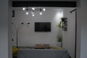 ein Wohnzimmer mit einem Sofa und einem TV an der Wand in der Unterkunft Nouvel Appartement Moderne À La Corniche De Bizerte in Bizerte