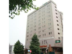 R&B Hotel Otsuka Eki Kitaguchi - Vacation STAY 14227v في طوكيو: مبنى ابيض كبير امامه اشجار