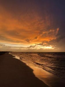 una puesta de sol en una playa con el océano y el cielo en Loft del mar, en Ciudad del Carmen