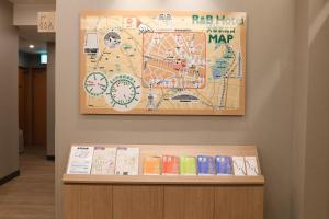 a map on a wall above a shelf with books at R&B Hotel Otsuka Eki Kitaguchi - Vacation STAY 40485v in Tokyo +6 photos