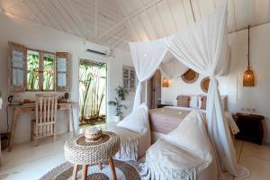 珀尼达岛Atalaya Villas Nusa Penida - Adults only的带天蓬床和桌子的卧室