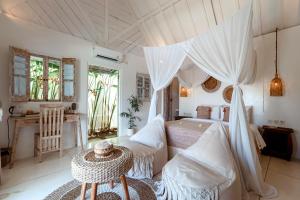 a bedroom with a canopy bed and a table at Atalaya Villas Nusa Penida in Nusa Penida