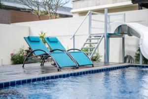 a pair of blue chairs next to a swimming pool at Luxury 250sqm Pool Villa in Central Location 5min to Beach & Walking Street! in Pattaya Central