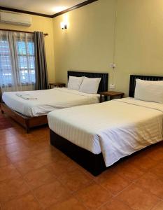 two beds in a hotel room with two bedsskirts at Nice view guesthouse in Vang Vieng