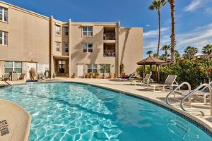 a swimming pool with chairs and a building at La Casita at Surfside 103 in South Padre Island