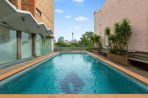 a swimming pool on the side of a building at Chic Studio with Pool Overlooking the City in Sydney