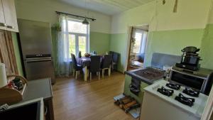 a kitchen with a stove and a kitchen with a table at Ķēniņi 